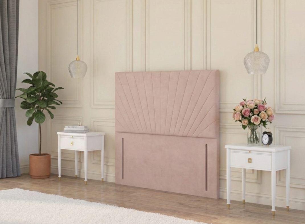 Blush pink floor standing velvet headboard in a classic room between two drawers, with roses and a houseplant in the corner. 