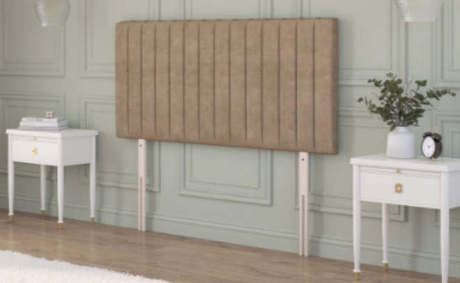 Chesterfield floor standing headboard in beige velvet, displayed between two black bedside tables in a classic interior.
